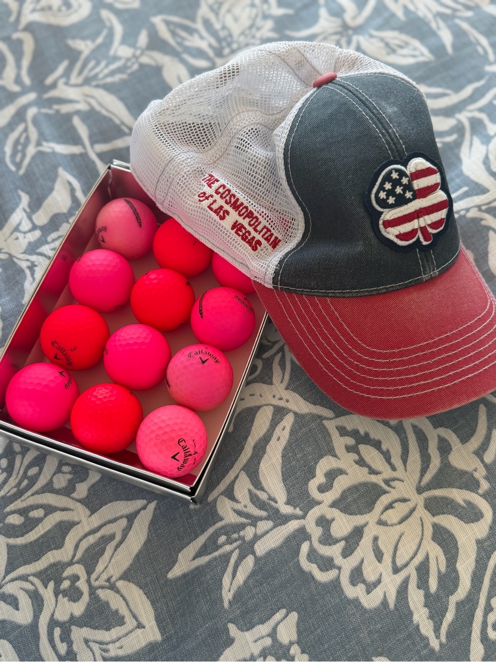 Black clover hat and soft, pink golf balls